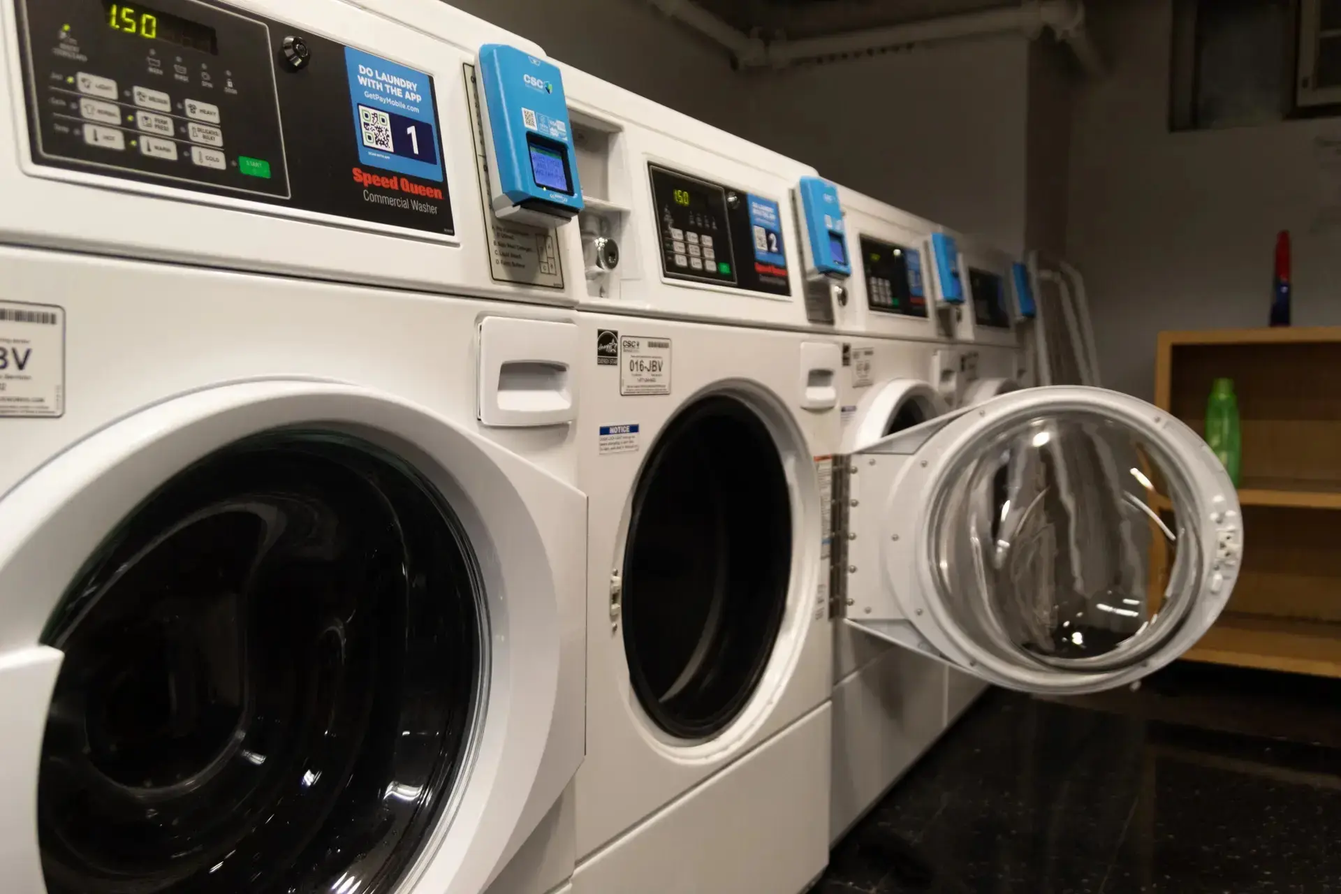 A row of white front-loading laundry machines